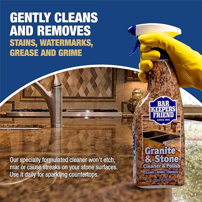 Bar Keepers Friend Granite & Stone Cleaner with a gloved hand holding the bottle, set against a kitchen background.